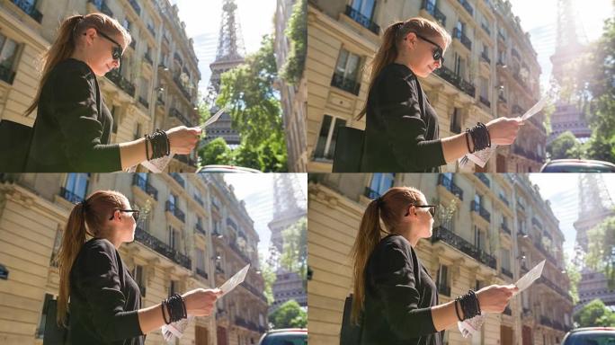 女人拿着巴黎地图，站在一条小巷里，可以看到埃菲尔铁塔