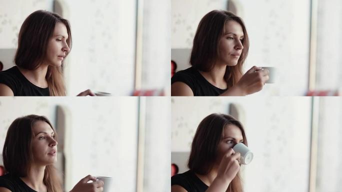一个漂亮的黑发女人的脸在喝杯咖啡或茶的特写镜头。她说话，微笑，玩得开心