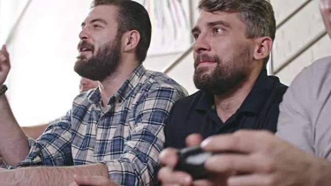 兴奋的男人在聚会上玩电子游戏