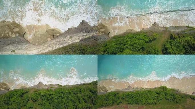 空中，特写: 梦幻般的巴厘岛的泡沫海浪溅到岩石悬崖上