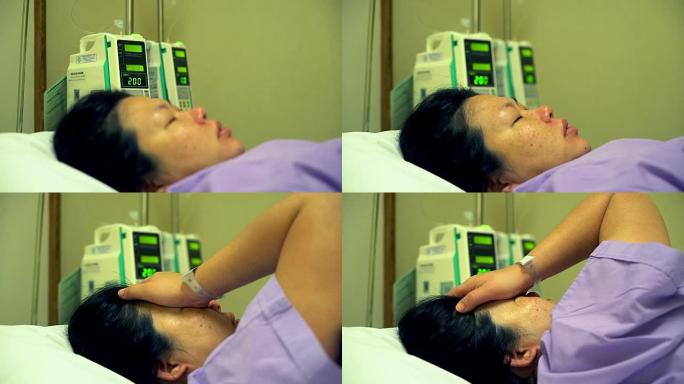 亚洲妇女躺在医院病床上的昏迷，她的儿子坐在她旁边