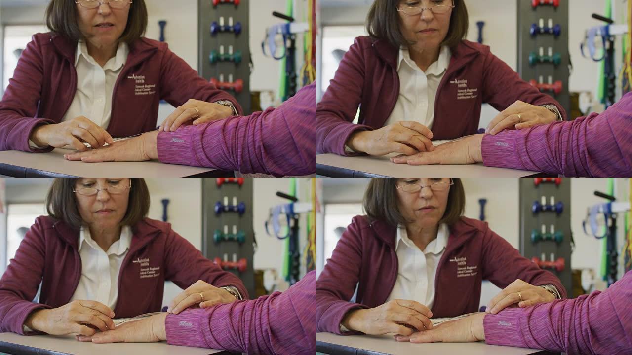 职业治疗师检查老年妇女手腕的活动性
