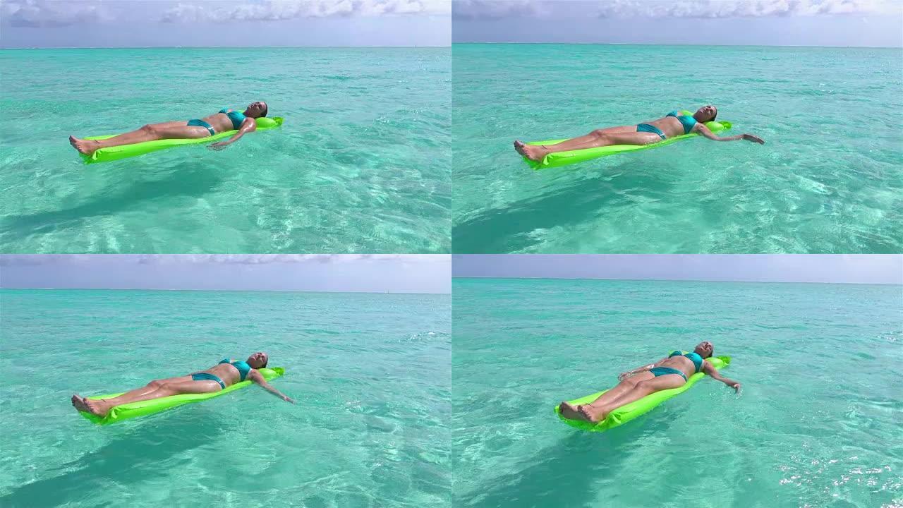 慢动作: 放松的女人在充气充气床上享受暑假