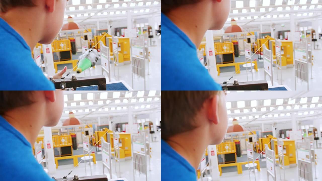 年轻的白人男孩在科学中心使用气压火箭
