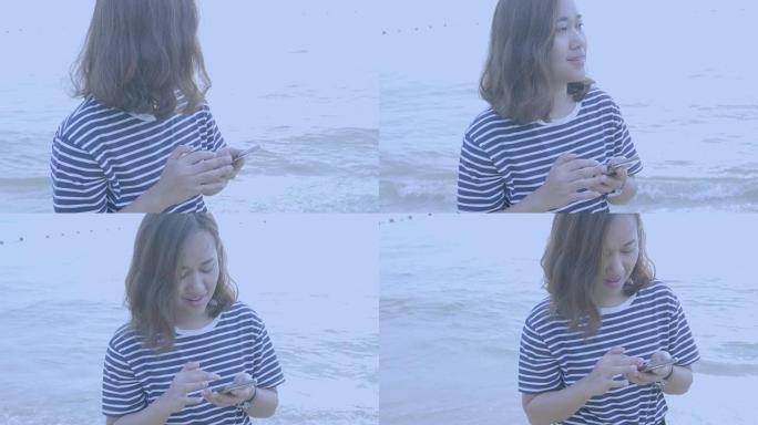 在海洋海滩拥有智能手机的亚洲女性