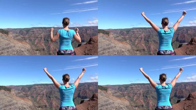慢动作: 山顶上快乐的年轻女子自豪地举起手臂