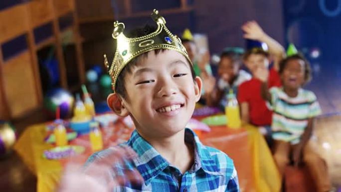 戴皇冠的男孩在4k生日派对上挥舞着手