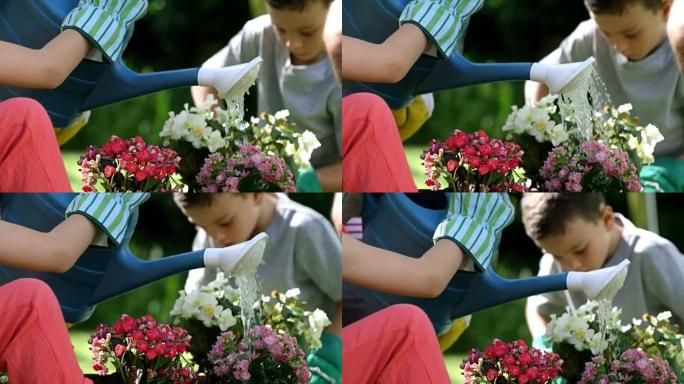 特写一个可爱的女孩在她的家人面前浇花