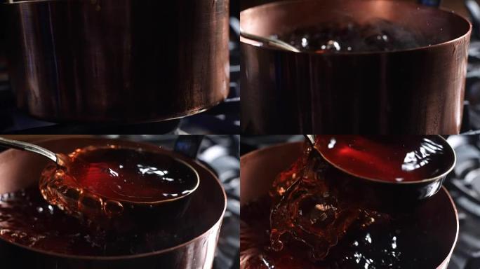 用勺子从铜锅中采摘樱桃汁