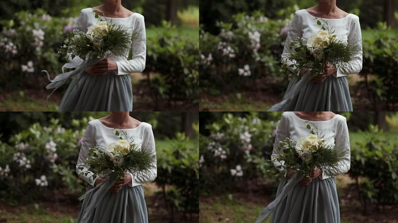 双手特写年轻时尚新娘在公园里捧着一束美丽的鲜花