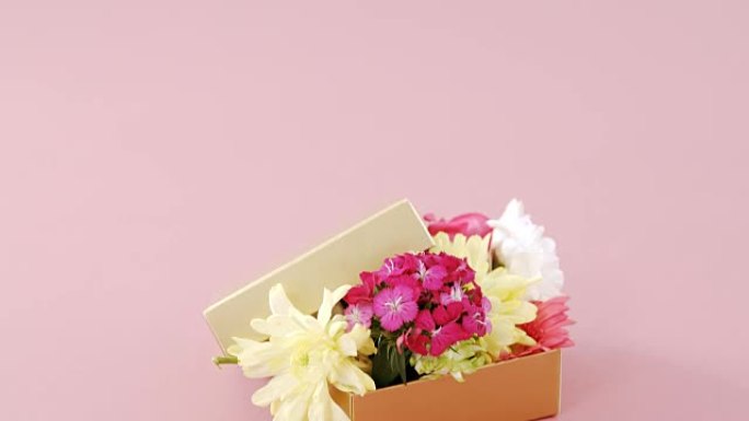 粉色背景下充满花朵的礼品盒