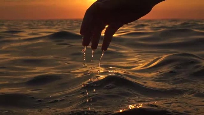 慢动作: 手玩海水，水滴从指尖掉落