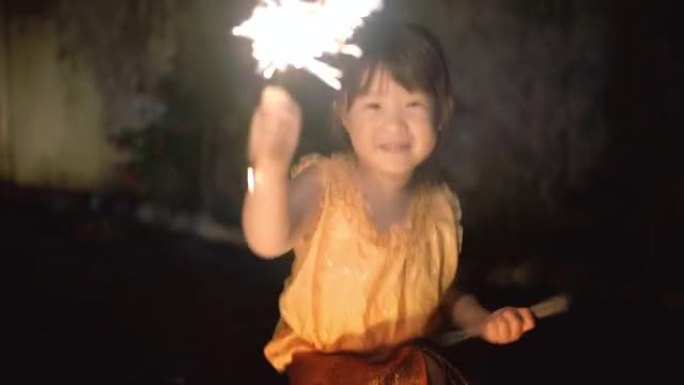 loi kratong节上穿着泰国连衣裙的小女孩配烟火