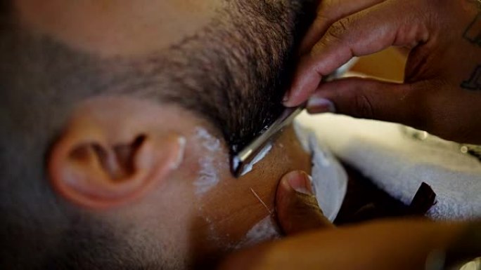 面目全非的理发师用经典剃刀刮胡子顾客