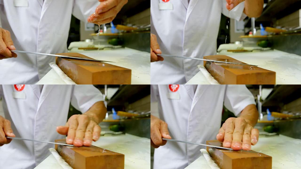 4k厨房磨刀石上的男厨师磨刀刀
