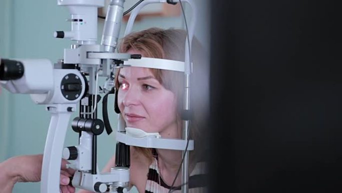 现代医疗程序。眼科医生在眼睛检查时将其指向触摸屏