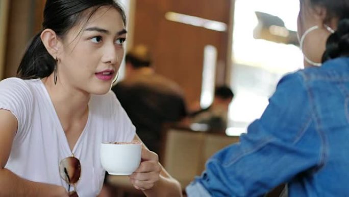 两个年轻女人在咖啡店里聊天。