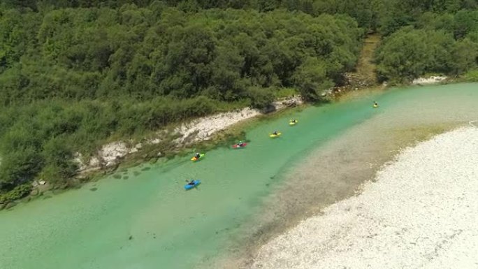 空中: 一群皮划艇运动员在阳光明媚的日子里滑下美丽的翡翠河