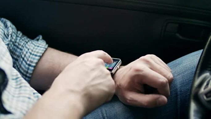 坐在汽车上使用智能手表的人的手