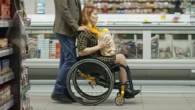 年轻截瘫妇女与男友在杂货店购物