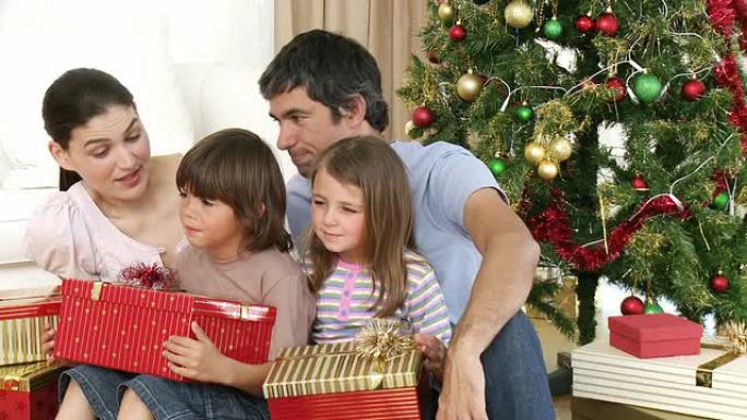 爱心家庭打开圣诞礼物坐在地板上