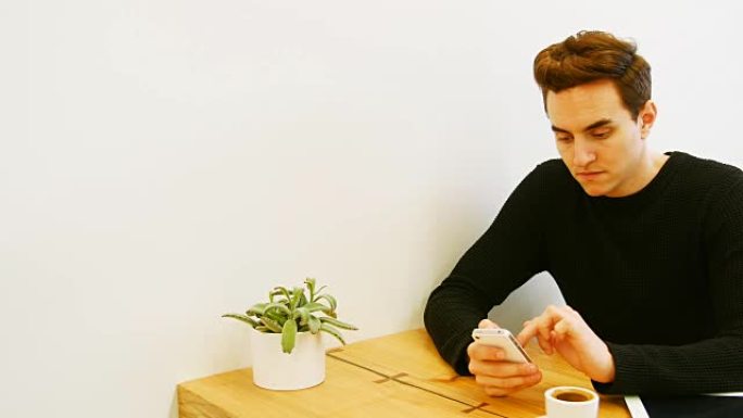 男人边喝咖啡边用手机