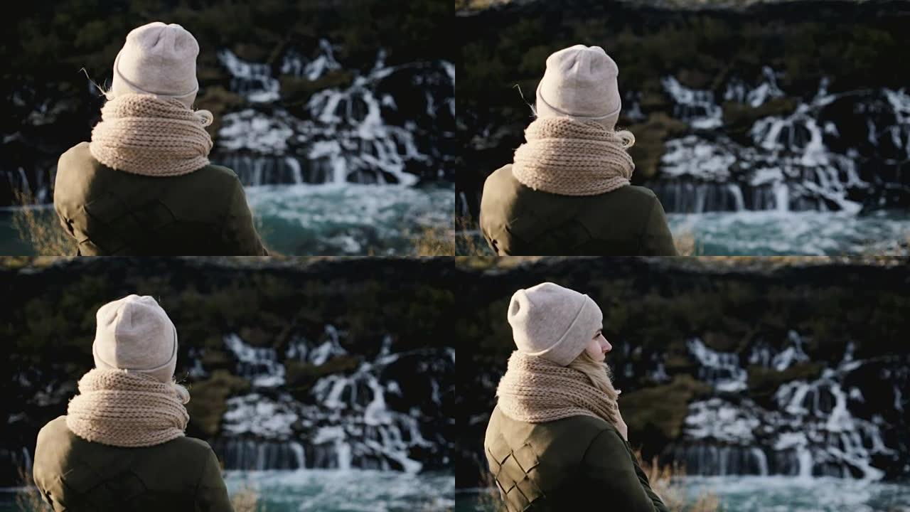 站在冰岛巴纳福斯瀑布附近欣赏风景的年轻美女的后景