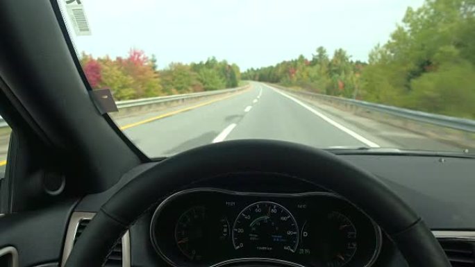 秋天，驾驶员的POV在空旷的高速公路上行驶，穿过华丽的彩色森林