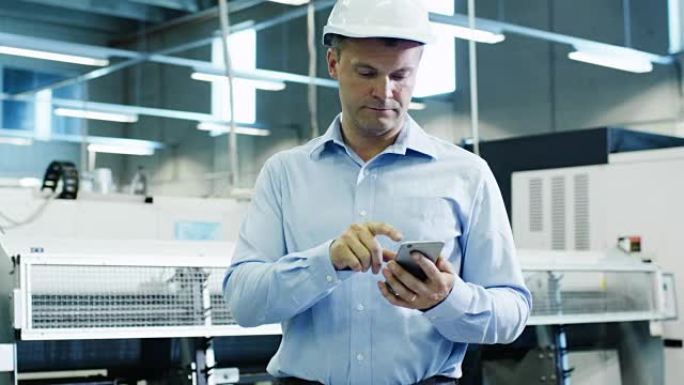 安全帽工程师在工厂使用手机