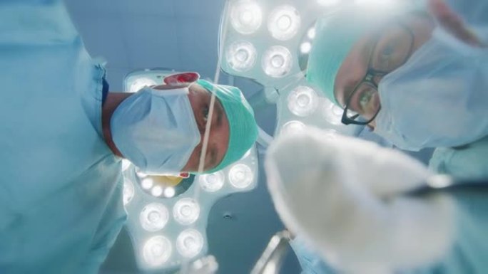 低角度镜头视点患者视图: 三名专业外科医生拿着手术器械开始手术。