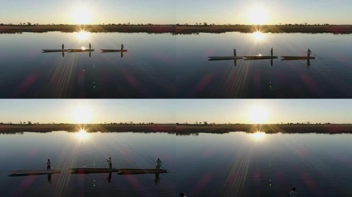空中飞越三个划桨者的轮廓，映衬在夕阳下，划着他们的Mokoros