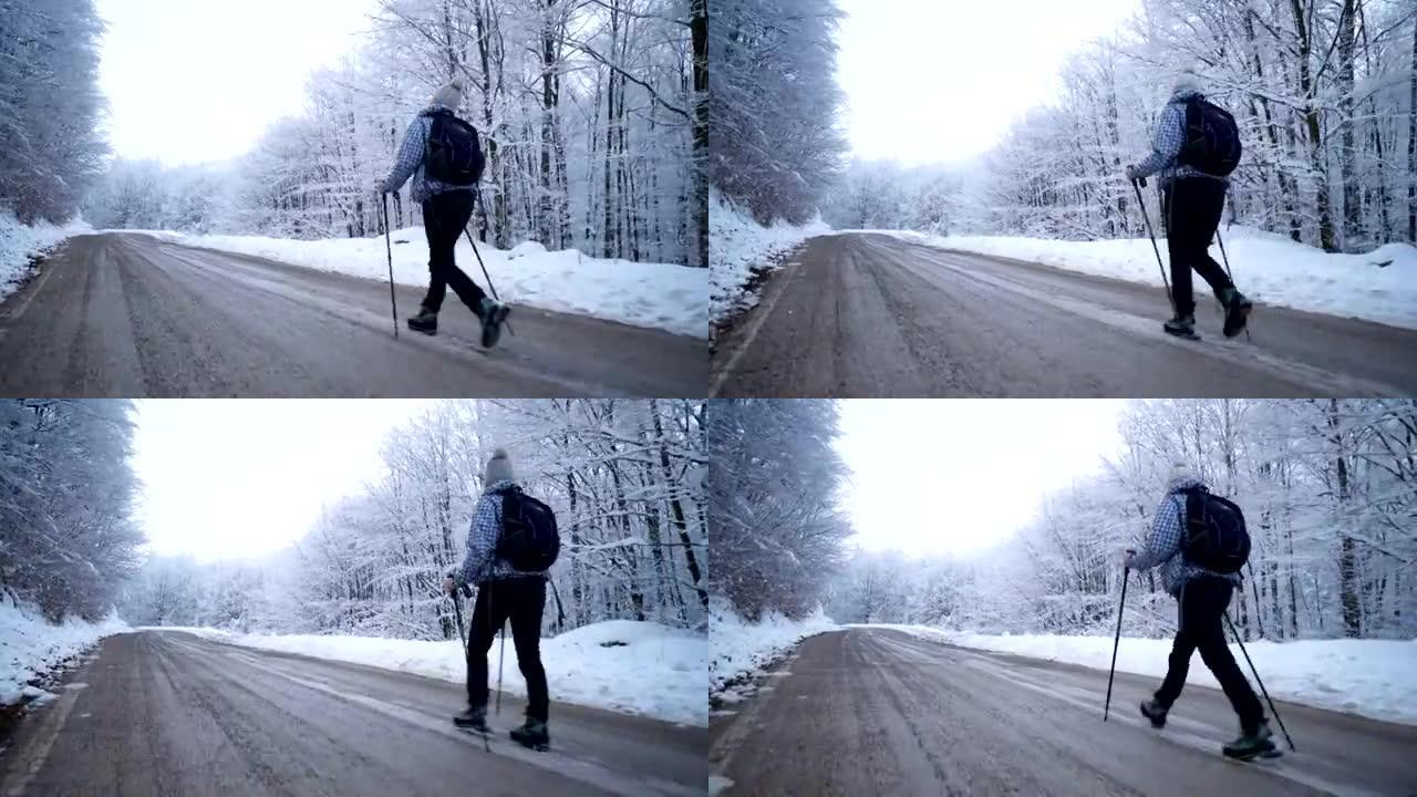 女徒步旅行者走在白雪皑皑的森林边的一条路上