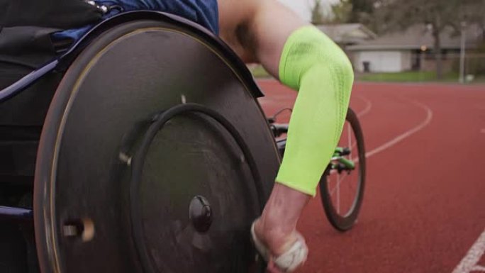 慢动作男副运动员推动赛车轮椅的轮辋