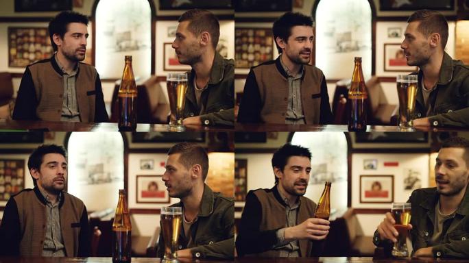 两个老朋友正在酒吧喝啤酒聊天。前景中的玻璃和瓶子，背景中的桌子和墙上的图片。