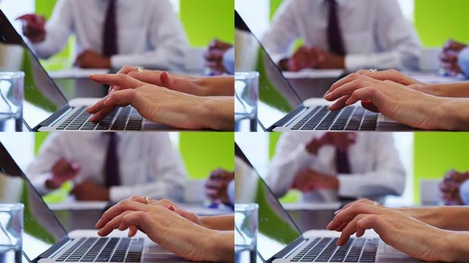 专注于女人在办公室使用笔记本电脑的手