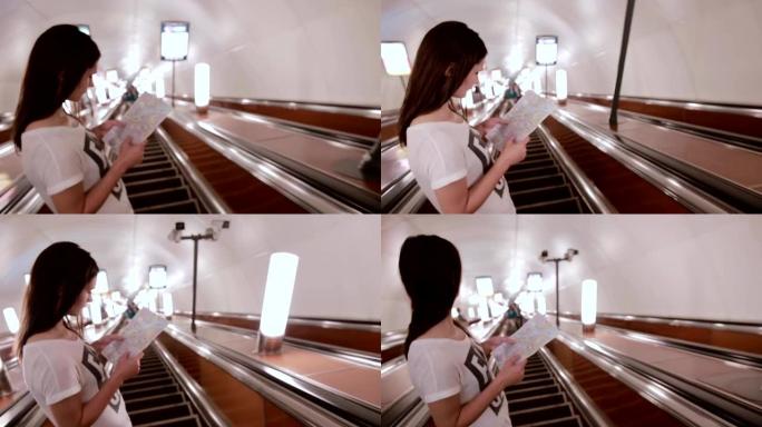 地铁里的漂亮女孩。一头黑发的年轻女子看着自动扶梯上的地图