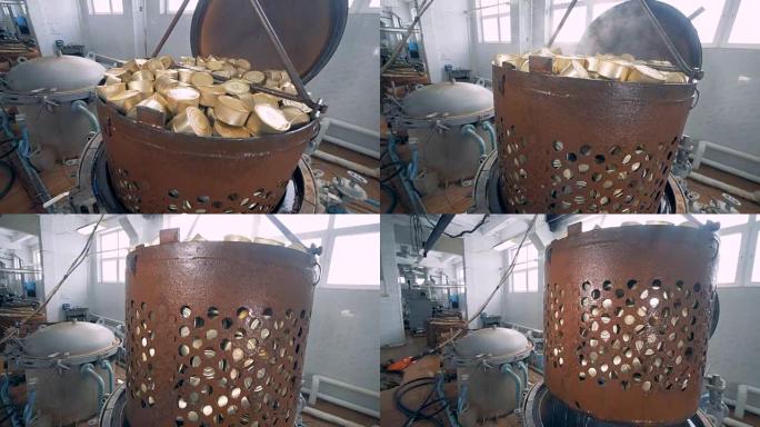 一个生锈的容器中的一堆锡罐正在从锅炉中升高