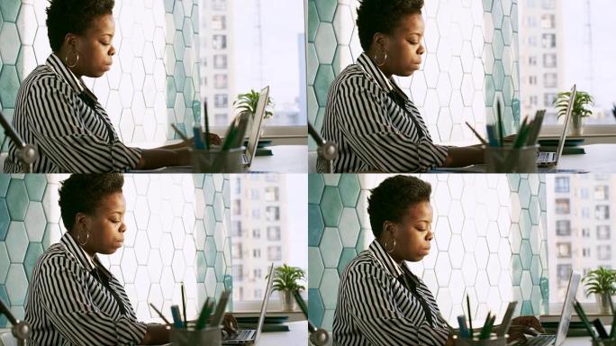 专注于非洲女士在笔记本电脑上打字