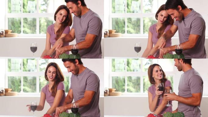 微笑的夫妇用红酒切碎蔬菜
