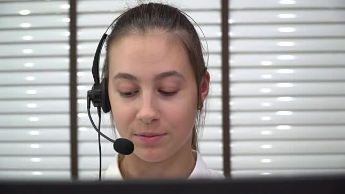 使用耳机在呼叫中心工作的年轻女子