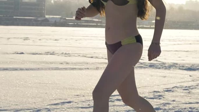 一个穿着泳衣的女人在降雪下奔跑。