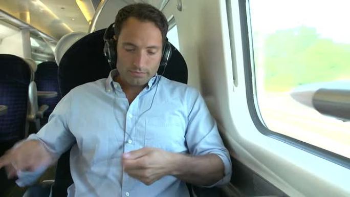 男子在火车旅行中听音乐