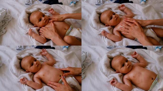 可爱的小宝宝在床上接受妈妈按摩4k