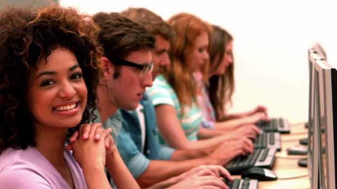 快乐的学生在计算机课上对着镜头微笑