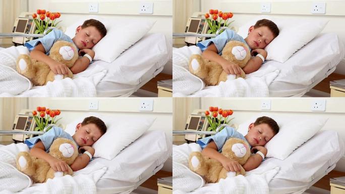 生病的小男孩和泰迪熊睡在床上