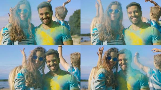 在胡里节上，一对幸福的夫妇的肖像被五颜六色的粉末覆盖着。背景中的人玩得开心扔胡里粉。