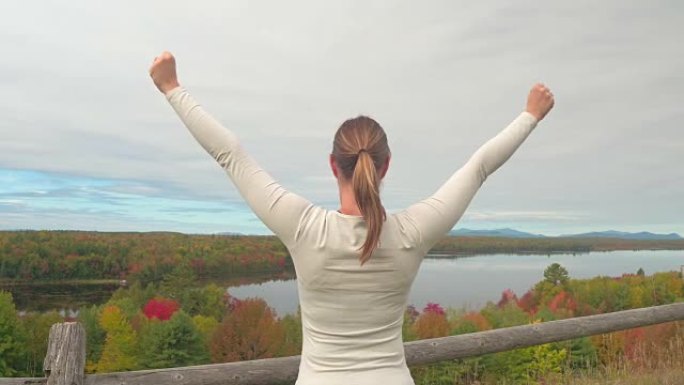 特写: 年轻女子伸出双臂俯瞰迷人的秋天风景