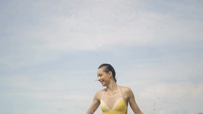 女子抱着黄色围巾跳入水中