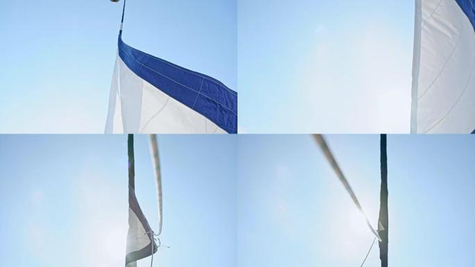 4k白色和蓝色帆船在晴朗的蓝天下风中航行，实时