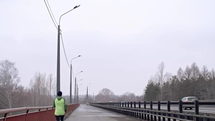 男子在沉闷的天气里在桥上慢跑